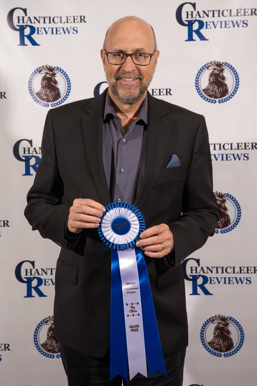 Kevin S. Moul holding the 2025 Shelley Award Grand Prize ribbon